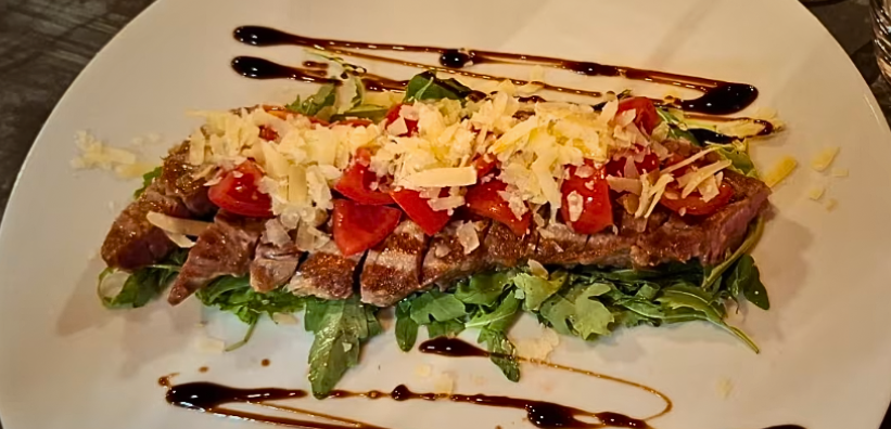 Tagliata di vitello con rucola, pomodorino e scaglie di grana 
